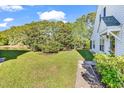 The side yard of this home features well-maintained lawn and mature shade trees at 182 Wimbledon Way # 182, Murrells Inlet, SC 29576