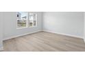 Bright bedroom with light wood flooring, white walls, and a large window at 2104 Copper Creek Ct., Longs, SC 29568