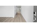 Bright hallway with stylish light wood flooring leading to a sunlit area at 2104 Copper Creek Ct., Longs, SC 29568
