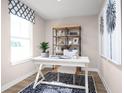 Bright home office featuring a white desk, stylish rug, and decorative shelving at 2521 Rowyn St., Longs, SC 29568