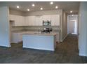 Modern kitchen with granite countertops, island, stainless steel appliances, and gray floors at 260 Warner Crossing Way, Loris, SC 29569