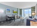 Well-decorated living room with a sofa, dining table, TV, and balcony access with an ocean view at 300 N Ocean Blvd. # 1026, North Myrtle Beach, SC 29582