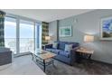 Comfortable living room with a sofa, coffee table, lamps, artwork and view to a balcony at 300 N Ocean Blvd. # 1026, North Myrtle Beach, SC 29582