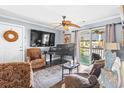 Cozy living room featuring a piano, comfortable seating, hardwood floors, and a sliding glass door to the outside at 380 Myrtle Greens Dr. # E, Conway, SC 29526