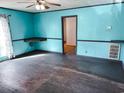 Living room featuring blue walls with painted trim, wood floors, and a fan at 422 S Magnolia Ave., Andrews, SC 29510
