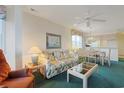 Living room open to dining area features a floral sofa and bright windows at 4257 Villas Dr. # 106, Little River, SC 29566