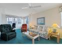 Cozy living room features a floral sofa, recliner, ceiling fan, and bright windows at 4257 Villas Dr. # 106, Little River, SC 29566