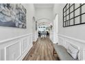 Elegant foyer with wood flooring, wainscoting, arched doorways, and stylish decor at 500 Canborough Lane, Murrells Inlet, SC 29576