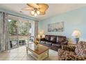 Inviting living room with tile floors, ceiling fan, and sliding glass doors to patio at 5801 Oyster Catcher Dr. # 1614, North Myrtle Beach, SC 29582