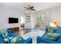 Bright living room boasts a ceiling fan, a TV, and access to a screened porch at 5801 Oyster Catcher Dr. # 724, North Myrtle Beach, SC 29582