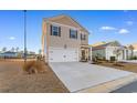 Inviting front exterior featuring a two-car garage, neutral siding, and landscaped front yard with a clear driveway at 706 Gryffindor Dr., Little River, SC 29566