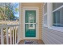 Condo front door with glass storm door, welcome mat, and building number 1001 at 1100 Commons Blvd. # 1001, Myrtle Beach, SC 29572