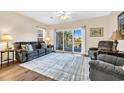 Comfortable living room featuring hardwood floors, neutral walls, a ceiling fan, and balcony access at 1100 Commons Blvd. # 1001, Myrtle Beach, SC 29572