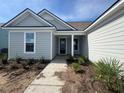 Inviting front entrance with covered porch, gray siding, and nicely planted landscaping at 1105 Oxeye St., North Myrtle Beach, SC 29582