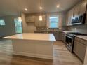 Modern kitchen with gray cabinets, stainless steel appliances, and a white island at 1229 Lady Bird Way, North Myrtle Beach, SC 29582