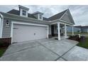 Exterior shot featuring a large two-car garage and concrete driveway leading to a charming gray home at 1257 Crested Iris Way, North Myrtle Beach, SC 29582