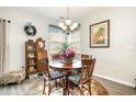 Cozy dining area featuring a round wooden table, floral accents, and soft natural light from the window at 1881 Moonseed Dr., Longs, SC 29568
