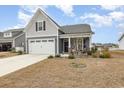 Charming home featuring a two-car garage, inviting front porch and manicured lawn in a friendly neighborhood at 1881 Moonseed Dr., Longs, SC 29568