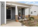 Inviting front porch with brick-based columns, seating area, and charming decor, creating a welcoming entrance at 1881 Moonseed Dr., Longs, SC 29568