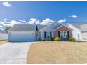 Lovely single-story home with a manicured lawn, attached garage and charming brick accents at 217 Sienna Dr., Little River, SC 29566