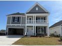 Charming two-story home boasts a welcoming front porch and a well-maintained lawn at 4035 Bucolic Loop, Myrtle Beach, SC 29588