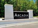 Community sign with the name Arcadia in white letters on a black background and surrounded by white brick pillars at 4035 Bucolic Loop, Myrtle Beach, SC 29588