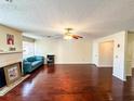Bright living room with a fireplace, shiny wood floors, a ceiling fan, and ample natural light at 488 Greenview Dr. # 1, Johnsonville, SC 29555