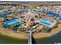 Aerial view of community center with pools, tennis courts, and clubhouse surrounded by lakes and homes at 5023 Middleton View Dr., Myrtle Beach, SC 29579