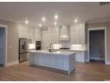 Modern white kitchen with stainless steel appliances, an island, and ample cabinet space at 5023 Middleton View Dr., Myrtle Beach, SC 29579