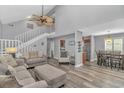 Open-concept living space showcasing modern flooring, staircase, comfortable seating, and connection to the dining area at 510 21St Ave. N, North Myrtle Beach, SC 29582