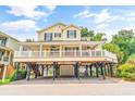 Charming yellow two-story home featuring a spacious porch, second story balcony, and stylish architectural details at 6001 - Mh69B South Kings Hwy., Myrtle Beach, SC 29575
