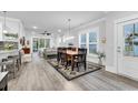 An open-concept dining room with modern floors, large windows and an adjacent living room at 6013 Tramonto St., Myrtle Beach, SC 29577