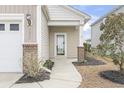 Inviting home entrance featuring a well-lit walkway, mature landscaping, and a covered entryway at 1097 Balmore Dr., Myrtle Beach, SC 29579