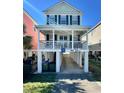 Charming two-story stilt home with a covered porch, perfect for enjoying the coastal breeze at 113B 13Th Ave. N, Surfside Beach, SC 29575