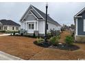 Charming single-story home featuring light gray siding, well-maintained landscaping, and a welcoming atmosphere at 135 Low Country Loop, Murrells Inlet, SC 29576
