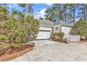Side view of a home featuring a two-car garage and neatly landscaped surroundings at 3026 Cedar Creek Run, Little River, SC 29566