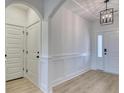 Hallway with decorative wainscoting, wood flooring, and a modern light fixture at 4028 Bucolic Loop, Myrtle Beach, SC 29588