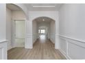 Bright hallway features stylish arches and light wood flooring leading into the living spaces at 4028 Bucolic Loop, Myrtle Beach, SC 29588