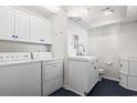 Well-organized laundry room boasts a washer, dryer, sink, and storage, blending functionality and a modern aesthetic at 4396 Baldwin Ave. # 138, Little River, SC 29566