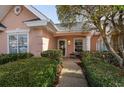 A walkway leads to the front entrance of a charming home surrounded by lush green bushes at 4545 Lighthouse Dr. # 28C, Little River, SC 29566