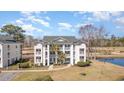 Scenic aerial view showcasing the condo, pond, golf course, and lush green surroundings at 597 Blue River Ct. # H2, Myrtle Beach, SC 29579