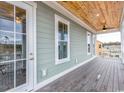 Covered balcony showcasing wood ceiling, ceiling fans, outdoor living space, and views at 8053 Laurel Ash Ave., Myrtle Beach, SC 29572