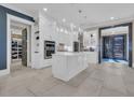 Spacious white kitchen with a central island, stainless steel appliances, tile backsplash, and modern pendant lighting at 823 Waterton Ave., Myrtle Beach, SC 29579