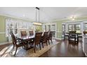 Elegant dining room with a long, dark wood table, cushioned chairs, and abundant natural light at 1043 Yellow Jasmine Dr., Longs, SC 29568