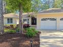 Home's meticulously landscaped front yard, features blooming flowers and lush greenery, enhancing curb appeal at 1043 Yellow Jasmine Dr., Longs, SC 29568