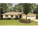 Beautiful house boasts well-kept lawn, flowerbeds, and two-car garage adding to its curb appeal at 1043 Yellow Jasmine Dr., Longs, SC 29568