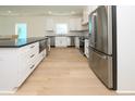 Bright kitchen with stainless steel appliances, white cabinets, and a farmhouse sink at 1211-B N Waccamaw Dr., Garden City Beach, SC 29576