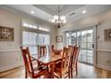 A beautifully lit dining room features a wood table, chandelier, and a sliding glass door to the backyard at 1411 Powhaton Dr., Myrtle Beach, SC 29577