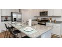 Modern kitchen features granite countertops, stainless steel appliances, and an eat-in island at 1450 Nokota Dr., Conway, SC 29526