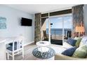 Cozy living room featuring sliding door access to balcony, TV, and comfortable seating with coastal decor at 161 Seawatch Dr. # 808, Myrtle Beach, SC 29572